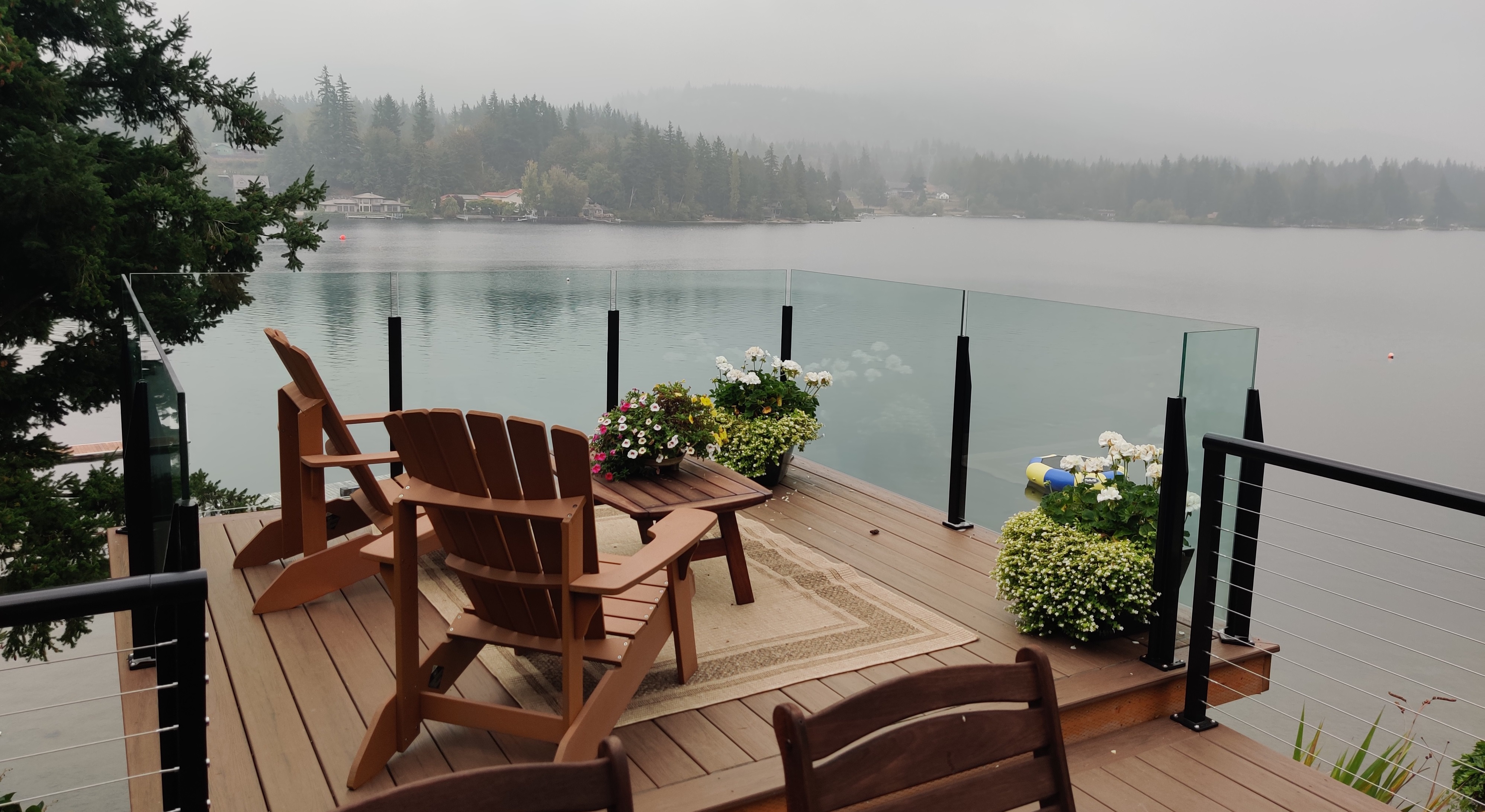 A hazy morning on Lake Whatcom viewed through glass and cable railing