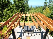 Full Rough Sawn (FRS) Western Red Cedar Pergola sitting on Fiberglass columns. This pergola covers a hot tub and patio made from pavers.