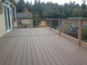 After photo of the Bellingham, WA deck renovation. Timbertech Terrains in Brown Oak with hidden fasteners surrounded by a cedar framed railing with galvanized infill.