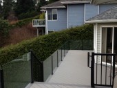 An Infinity topless glass railing installed on an Azek PVC deck overlooking Chuckanut Bay in Bellingham, WA.