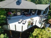 Topless glass railing with Timbertech Radiance Rail posts with postcap lighting. This railing is installed on a Azek deck.